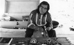 Native American man working on crafts poses for a picture