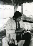 Native American man works on blowgun