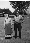 Native American man and woman stand outside near mound