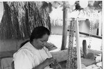 Native American woman works on crafts outside