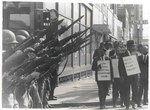 Striking Memphis sanitation workers march by National Guardsmen, 1968