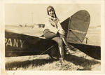 Phoebe Omile, sitting on back of plane, circa early 1920s
