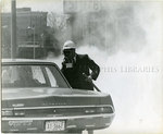 Policeman wearing a gas mask, Memphis, 1968 by Jim Shearin